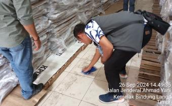 Photo Ardiyanto cek Gudang logistik dengan menuangkan air di lantai gudang kpu oku. 